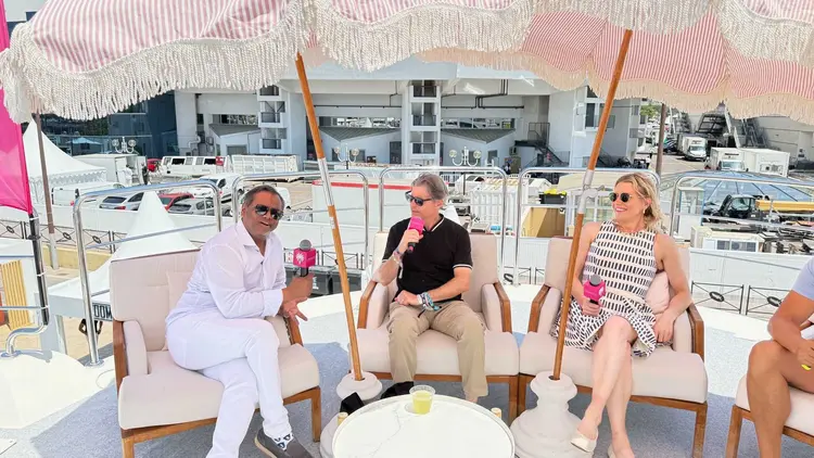 People with microphones under umbrella